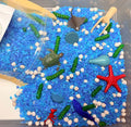 Ocean Dive ready-to-pour sensory play kit with ocean-themed filler and sea animal play pieces.